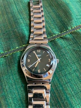 Swatch Women’s Silver Bracelet Watch with Dark Green Dial.